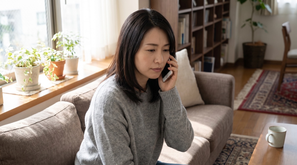 自宅で痛みや腫れが気になり、クリニックに電話で相談している様子