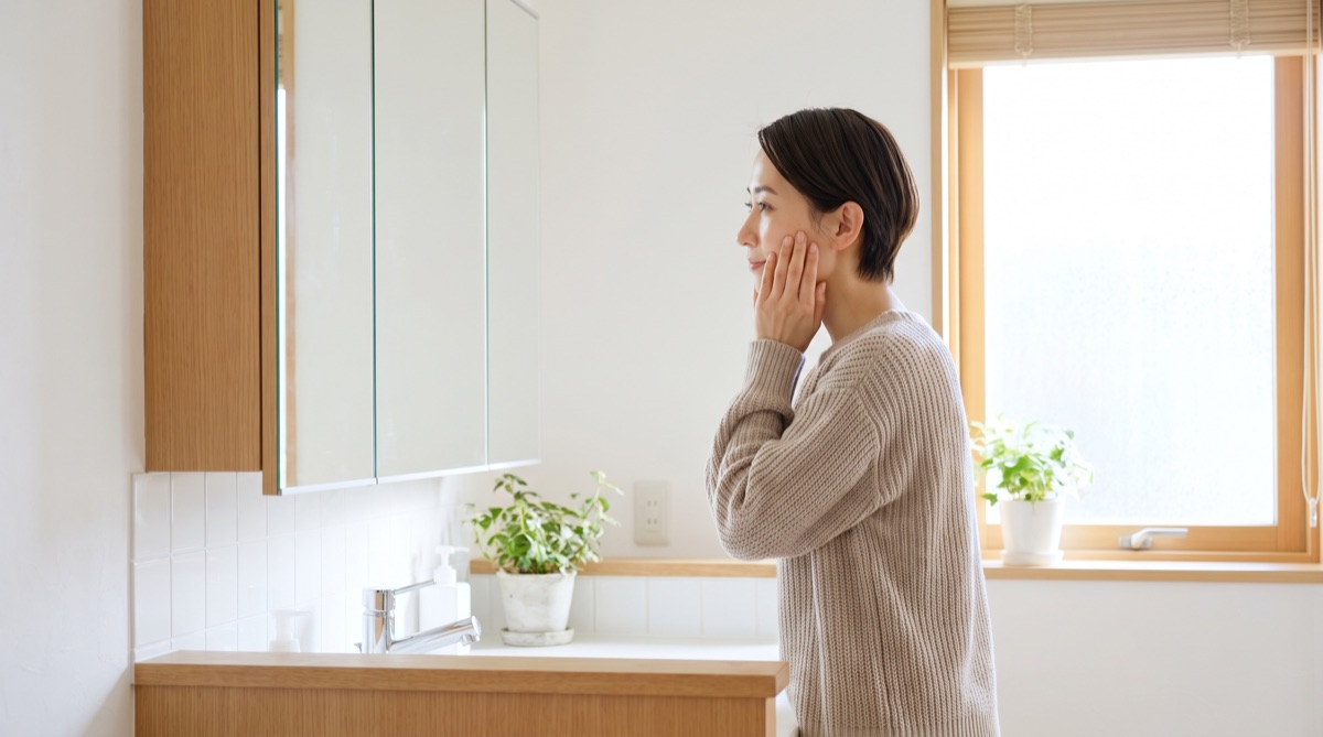 鏡の前で気になる部分を確認し、吸引したい範囲を言葉にしようとしている様子